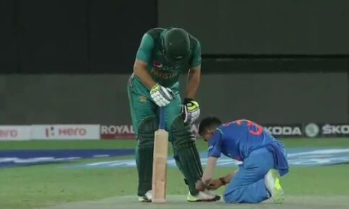 Indian cricketer helps Pakistani player tie a shoelace Indian cricketer helps Pakistani player tie a shoelace